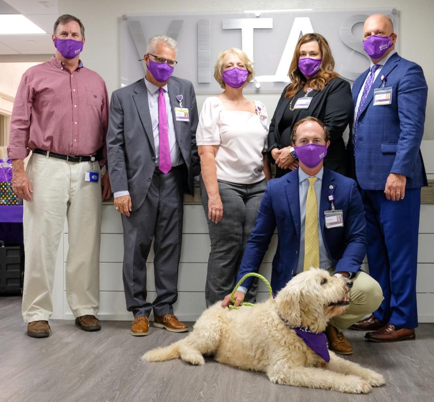 The VITAS team together in the lobby with a Paw Pals pet visit dog