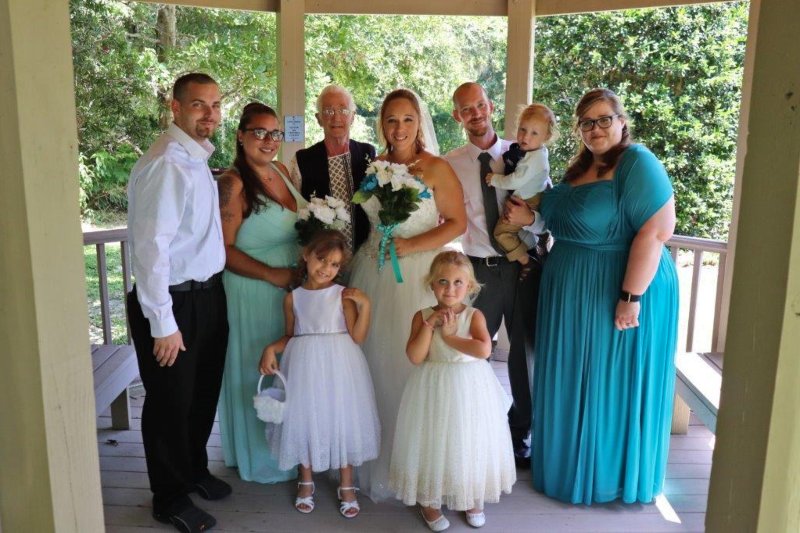 The wedding party gathered under a gazebo for pictures