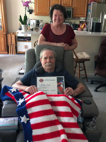 VITAS patient William Slack shows the certificate he received from VITAS, with his wife Roxanne standing behind him