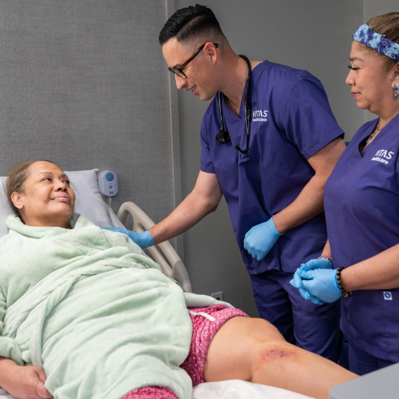 A VITAS nurse at the bedside of a patient who is at his home