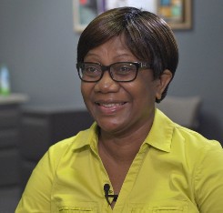 Mervel smiles while talking in the office